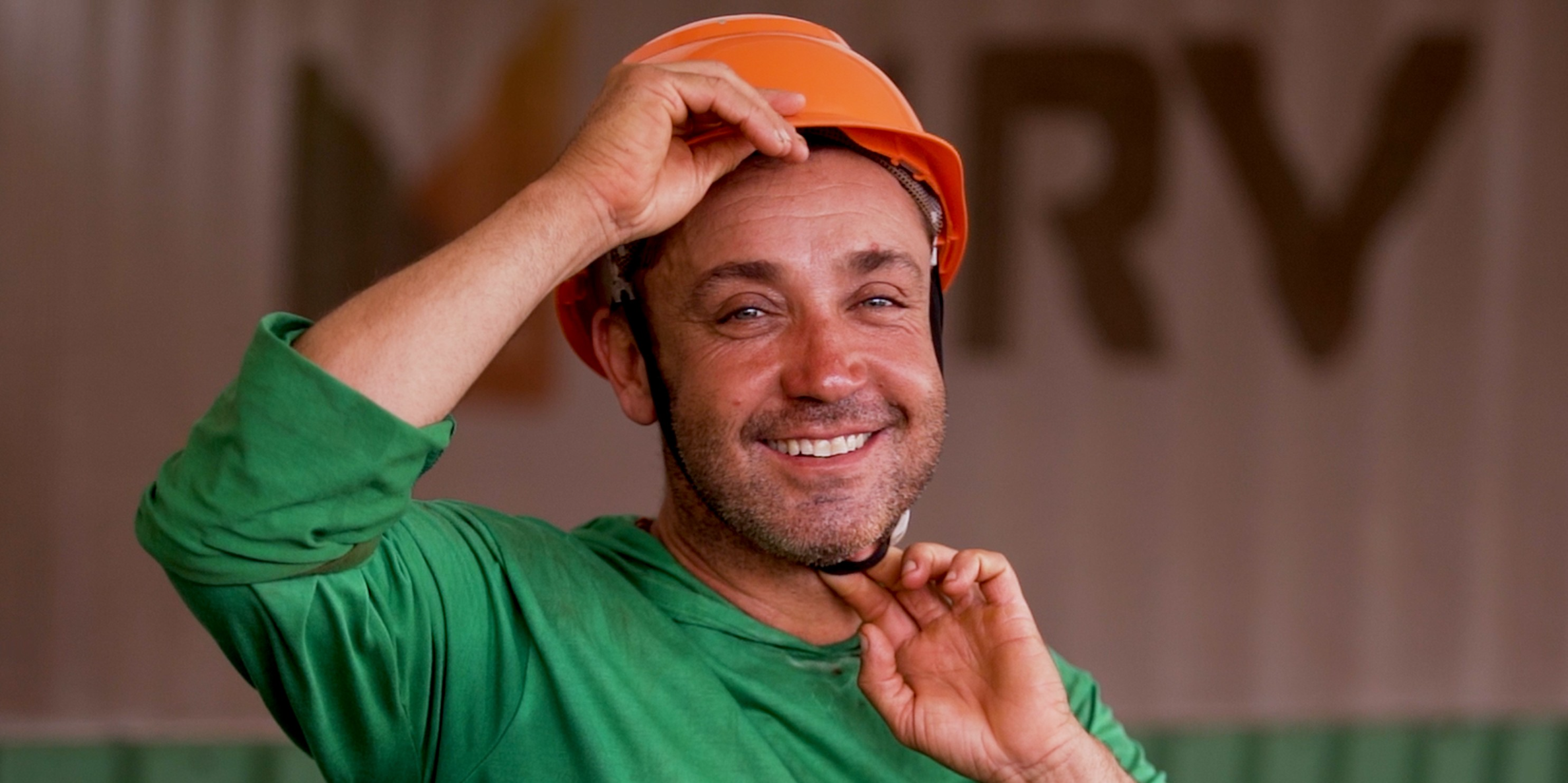Funcionário Éder Bergamo sorrindo enquanto coloca capacete de proteção em obra da MRV